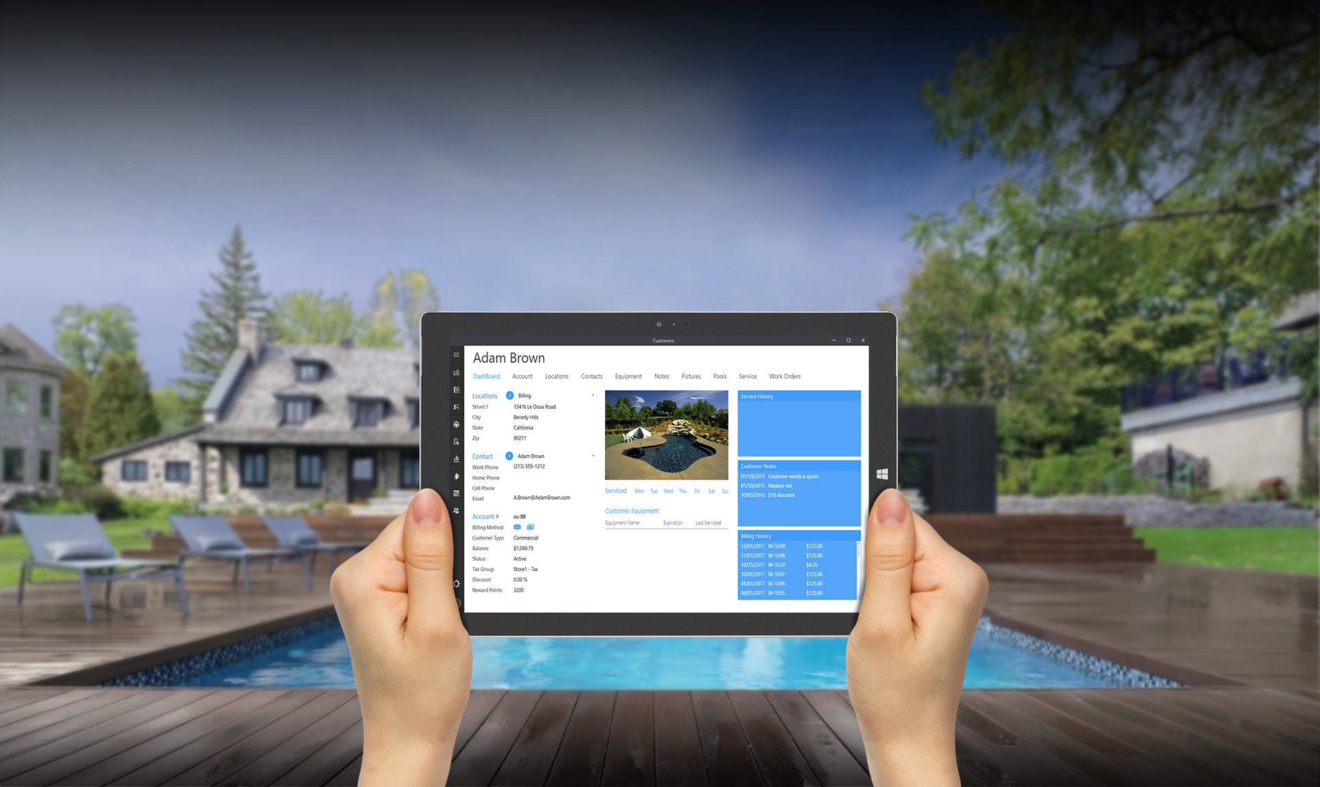 A person holding a Surface tablet displaying Wise Software - Enterprise and a house in the background.